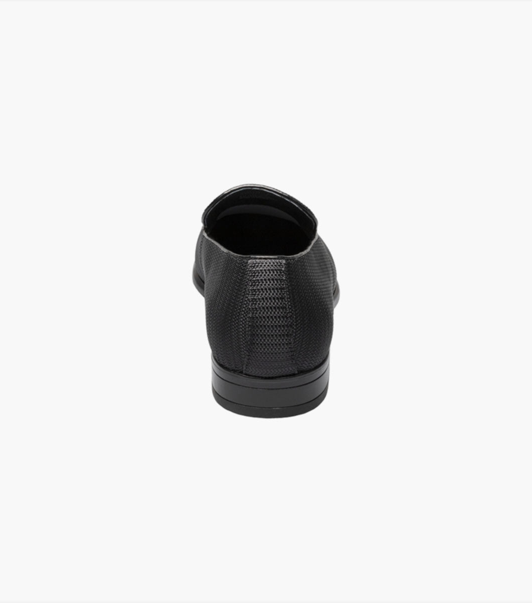 A pair of Stacy Adams Black Tazio Moc Toe Bit Slip-on Shoes with a textured knit fabric upper and Memory Foam footbed on a white background.