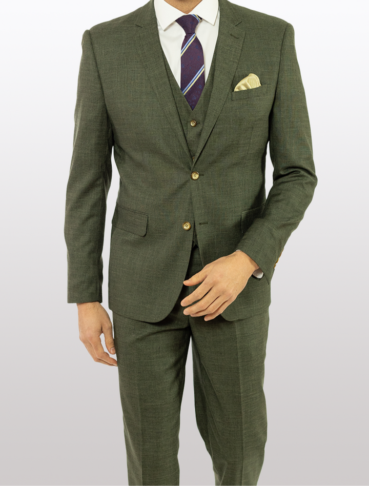 A man in a FUBU Olive Green Solid Vested Suit from Fubu The Colle, paired with a white shirt and a purple striped tie, stands against a plain background.