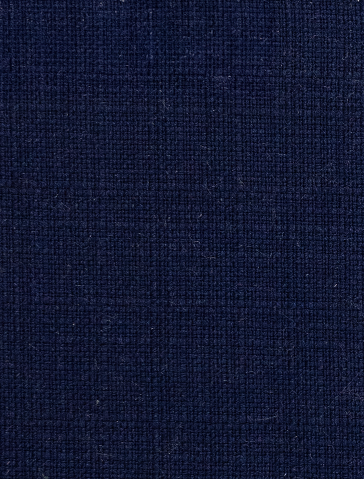 Detailed view of the FUBU Berry Blue Vested Suit by Fubu The Colle, featuring a navy blue textured fabric with a subtle crisscross pattern, ideal for crafting a modern fit suit.