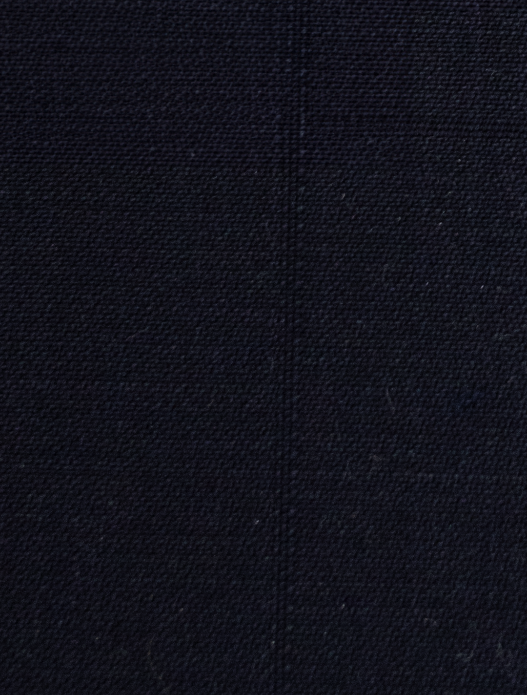 A close-up of the FUBU Midnight Navy Vested Suit by Fubu The Colle showcases a coarse, woven texture and a visible vertical seam, perfect for a modern fit.