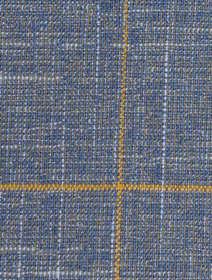 Close-up of a Fubu The Colle FUBU Steel Blue with Mustard Windowpane 2-Piece Suit, showcasing its blue and gray woven texture and stylish large yellow cross pattern. The modern fit design enhances its sleek appearance, combining contemporary flair with classic style.