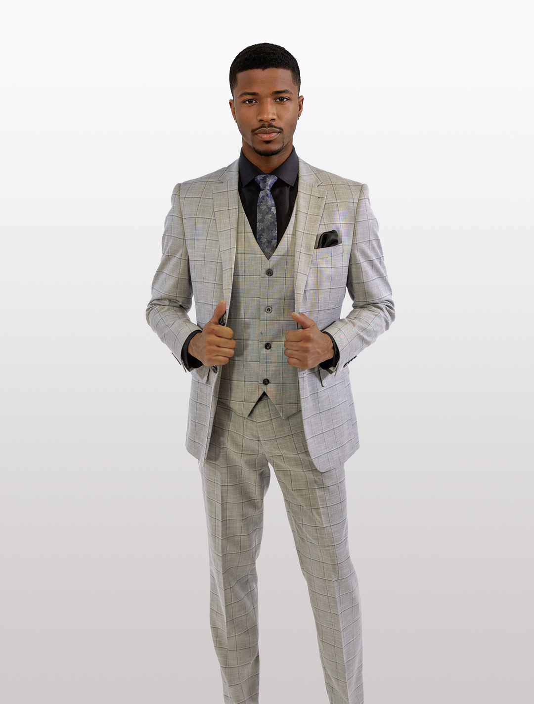A man in a FUBU Light Grey with Charcoal Windowpane Vested Suit by Fubu The Colle, paired with a black shirt, gives two thumbs up.