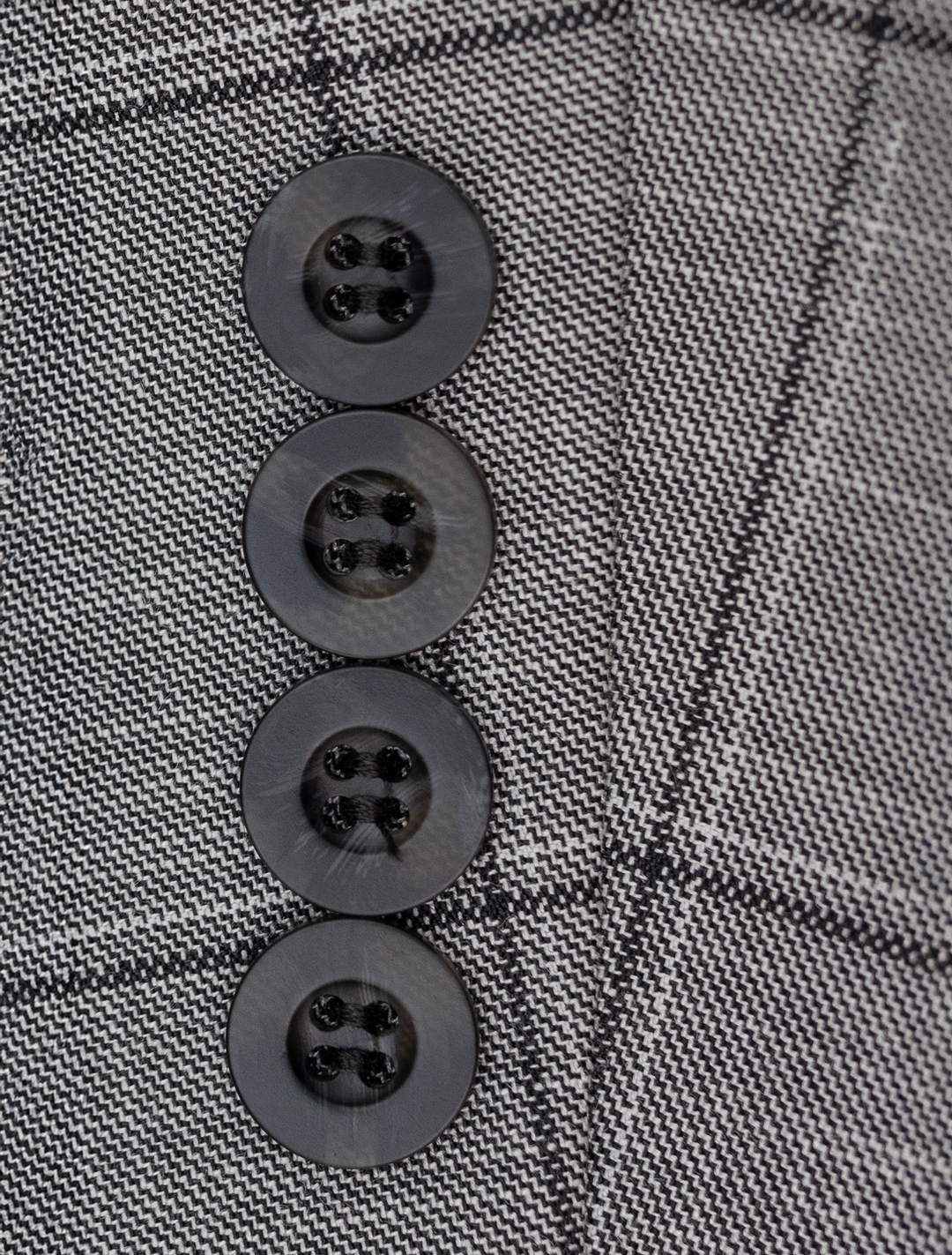 Close-up of four black buttons on the FUBU Light Grey with Charcoal Windowpane Vested Suit&