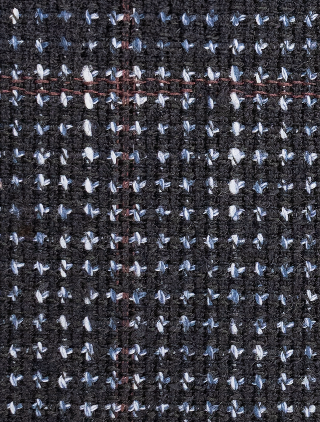 Close-up of the textured navy tweed with a grid pattern found in the FUBU Textured Navy with Brick Windowpane Sport Jacket by Fubu The Colle, featuring white, blue, and thin red threads throughout.