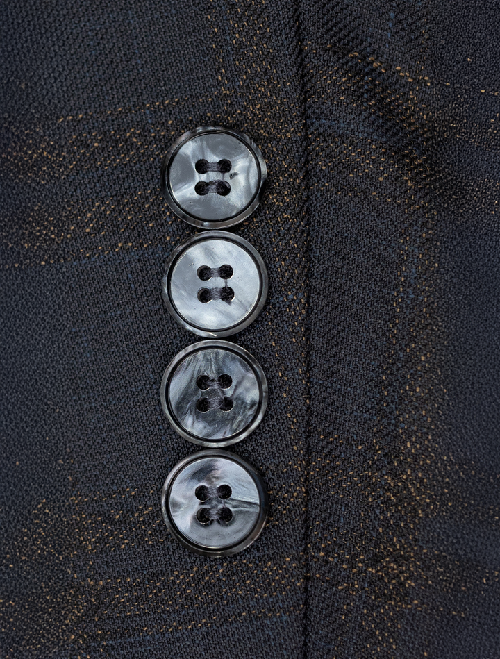 Close-up of four dark gray buttons on a textured fabric, showcasing the essence of the FUBU Navy with Bronze Windowpane Peak Lapel Tuxedo Jacket by Fubu The Colle.