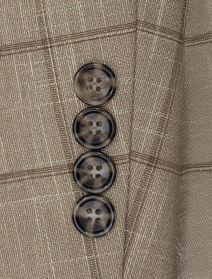 Close-up of a sleeve on the FUBU Camel with Mocha Windowpane 2-Piece Suit by Fubu The Colle, featuring four dark, round buttons in a vertical line, combining classic style with a modern fit.