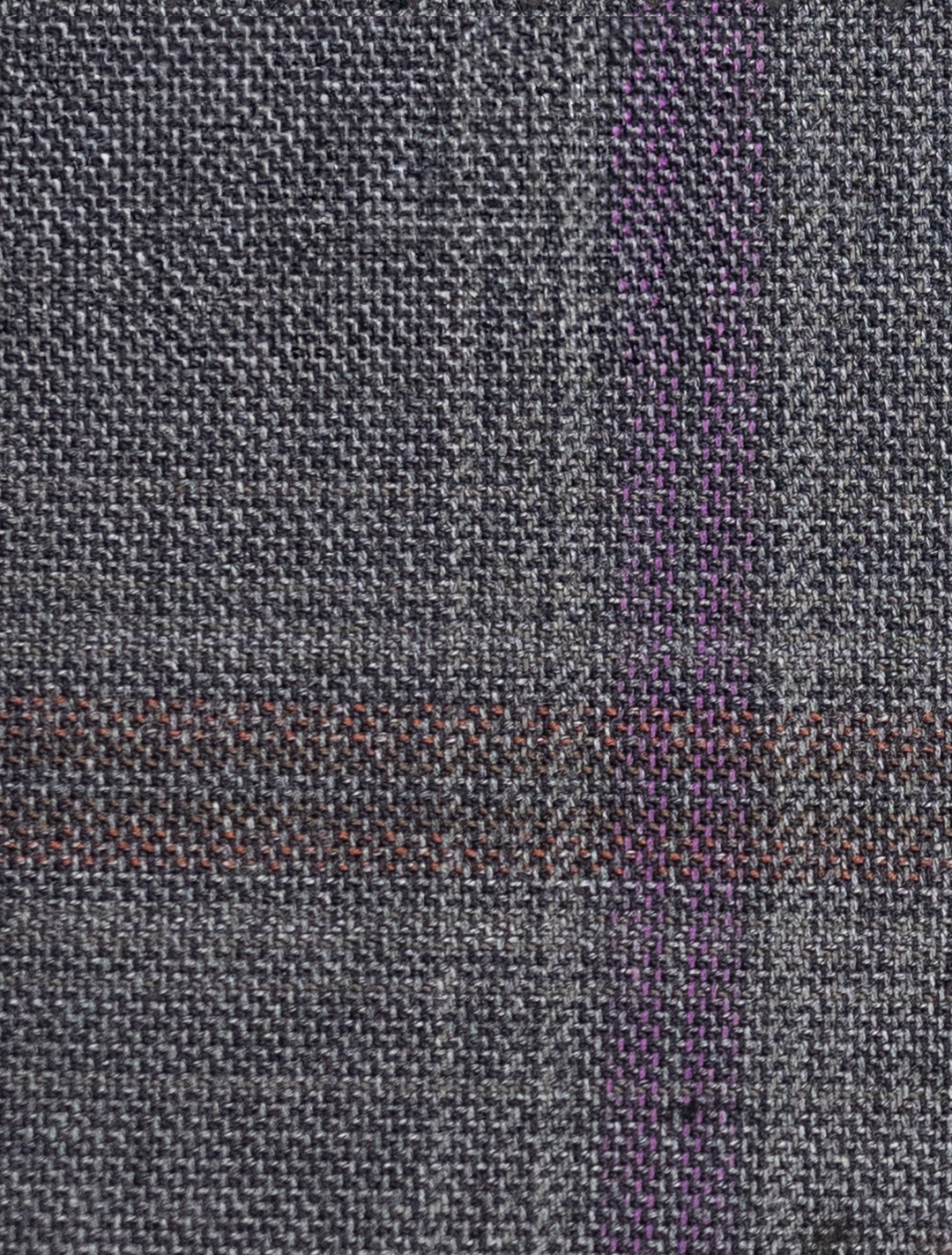 A close-up of the FUBU Charcoal with Purple Windowpane Vested Suit by Fubu The Colle highlights its textured gray fabric with a grid pattern and subtle purple lines, ideal for a slim fit suit.