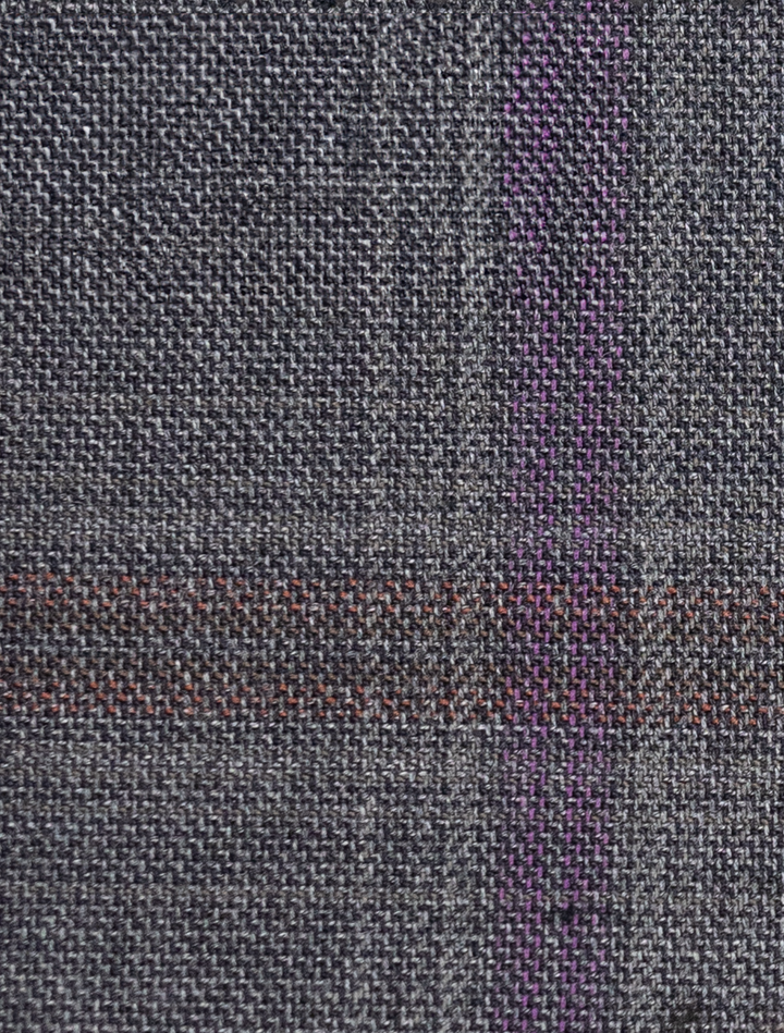 A close-up of the FUBU Charcoal with Purple Windowpane Vested Suit by Fubu The Colle highlights its textured gray fabric with a grid pattern and subtle purple lines, ideal for a slim fit suit.