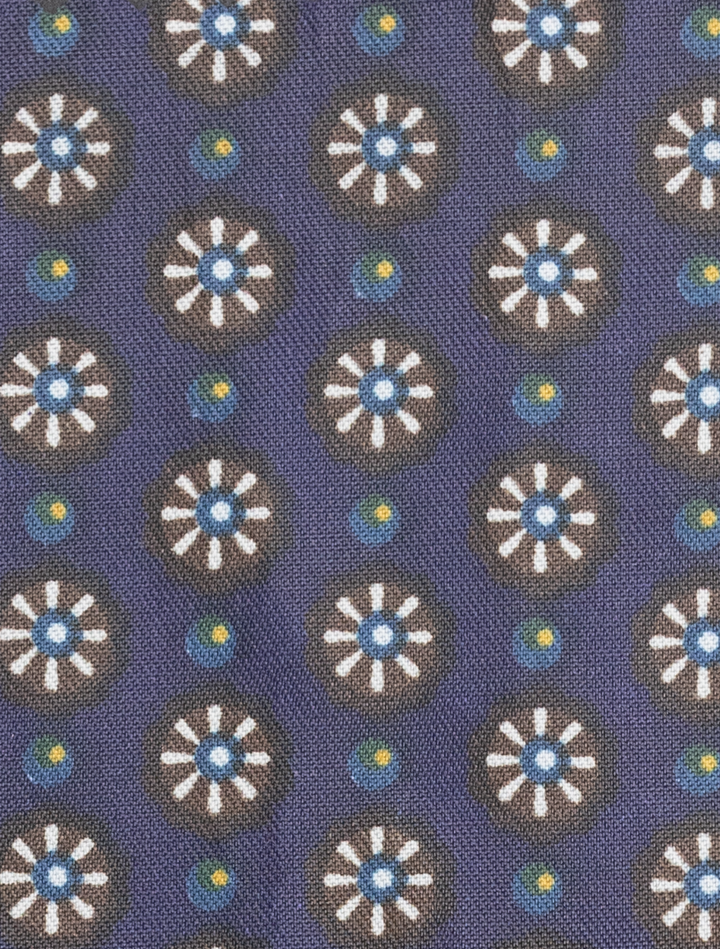 Modern fit fabric featuring white and blue floral motifs with yellow dots on a dark blue background, designed for a sleek silhouette in the FUBU Mauve Taupe with Purple Windowpane Vested Suit by Fubu The Colle.