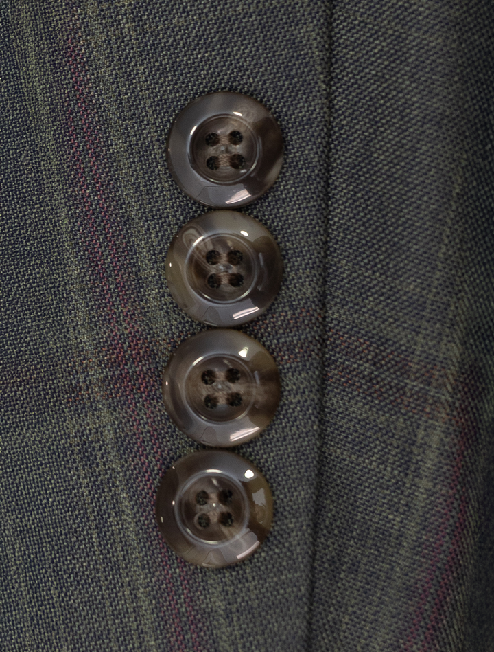 Close-up of four brown buttons on the sleeve of a slim-fit FUBU Olive with Mahogany Windowpane 2-Piece Suit by Fubu The Colle, crafted from premium Tetron Rayon fabric.