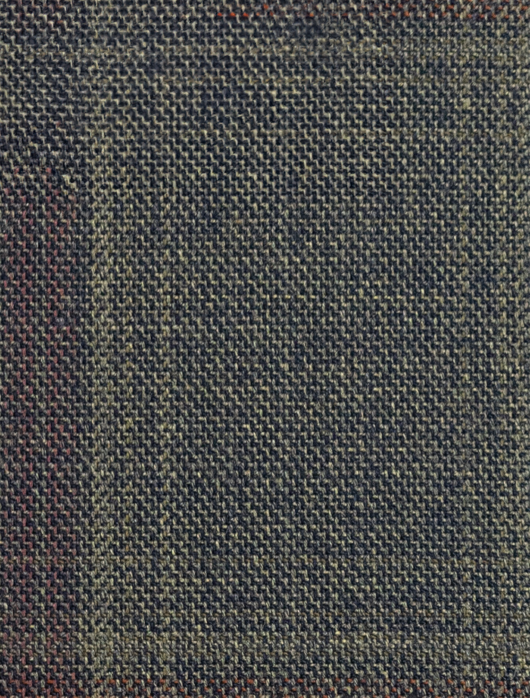 Close-up of textured dark green and brown fabric featuring a grid pattern, perfect for the FUBU Olive with Mahogany Windowpane 2-Piece Suit by Fubu The Colle. The finely interwoven high-quality Tetron Rayon creates a subtle checkered design ideal for a slim fit.