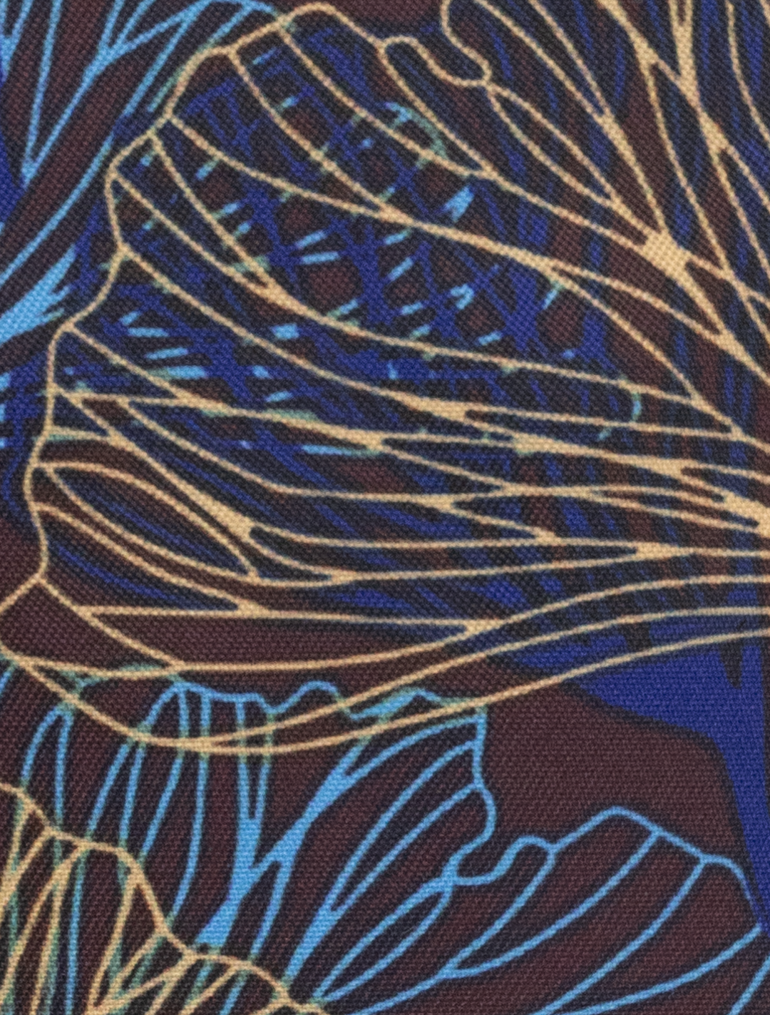 Close-up of abstract fabric pattern with overlapping blue and gold lines like leaves or wings on a dark background. The Tetron Rayon material adds elegance, ideal for a slim fit suit. Introducing the FUBU Olive with Mahogany Windowpane 2-Piece Suit by Fubu The Colle.