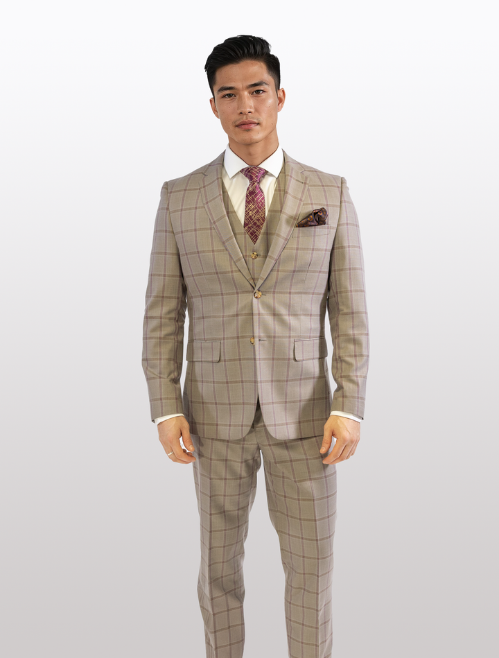 Wearing a FUBU Tan with Maroon Windowpane Vested Suit by Fubu The Colle, a person stands confidently against a plain background, paired with a crisp white shirt and patterned tie.