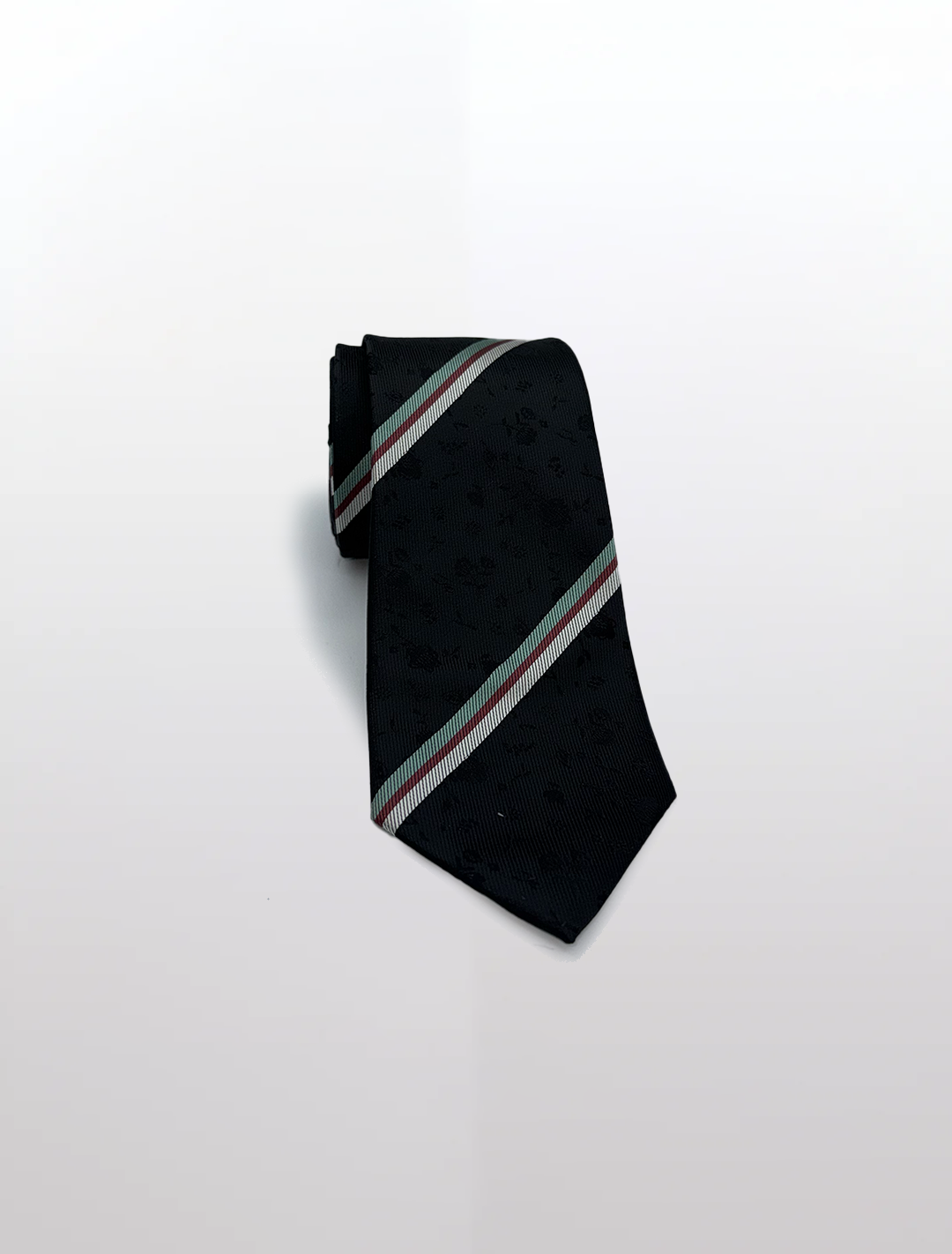 A black microfiber tie with a green, red, and silver regimental floral pattern adds the perfect touch to groomsmen suits. A sleek accessory from Karako Collecti, it stands out on a plain background effortlessly.
