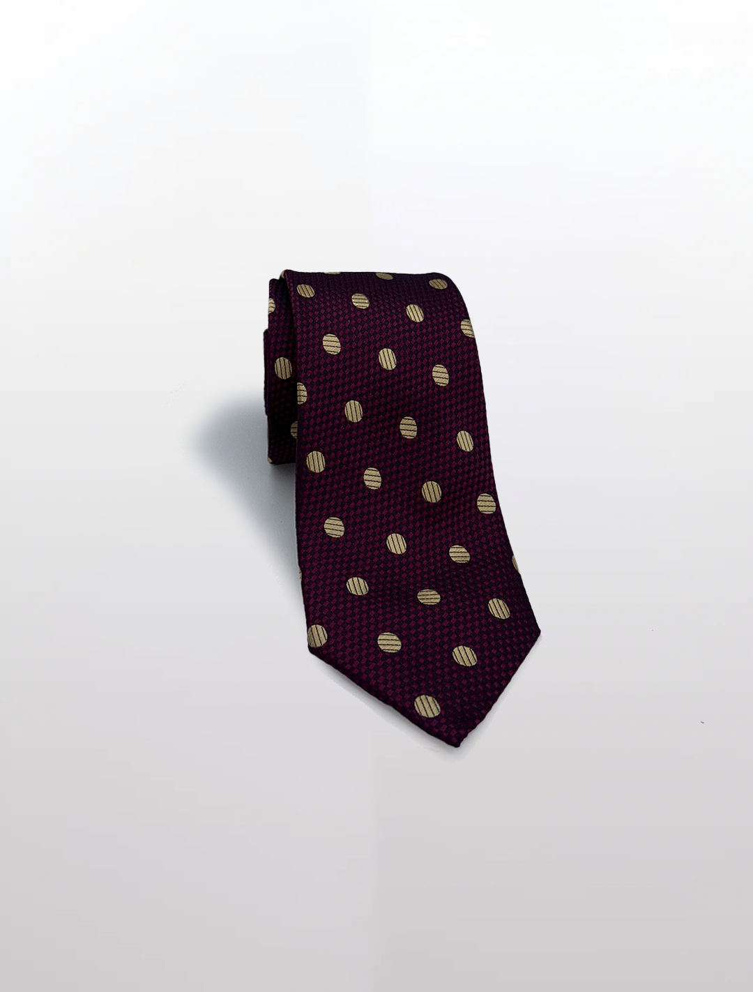 A rolled-up Pink with Gold Polka Dot Patterned Microfiber Tie by Karako Collecti, perfect for complementing Karako Suits or adding a dash of personality to groomsmen suits.
