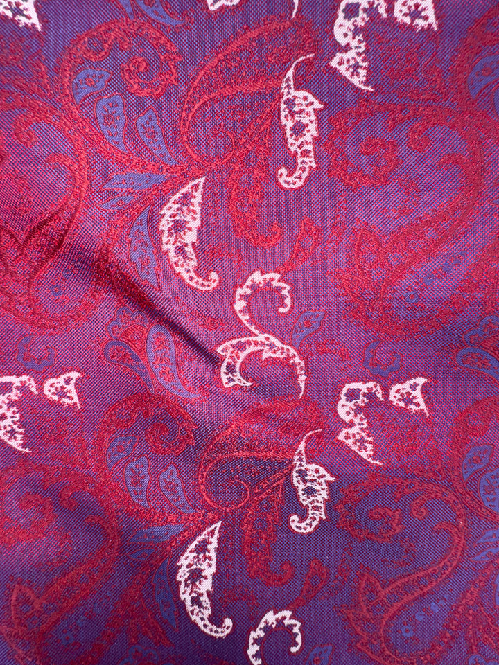 Close-up of the Burgundy Floral Pocket Square Handkerchief by Karako Collecti, showcasing a rich burgundy microfiber base adorned with an elegant floral pattern. The fabric’s subtle creases and detailed texture emphasize its wrinkle-resistant quality, making it a charming and practical accessory for formal occasions.