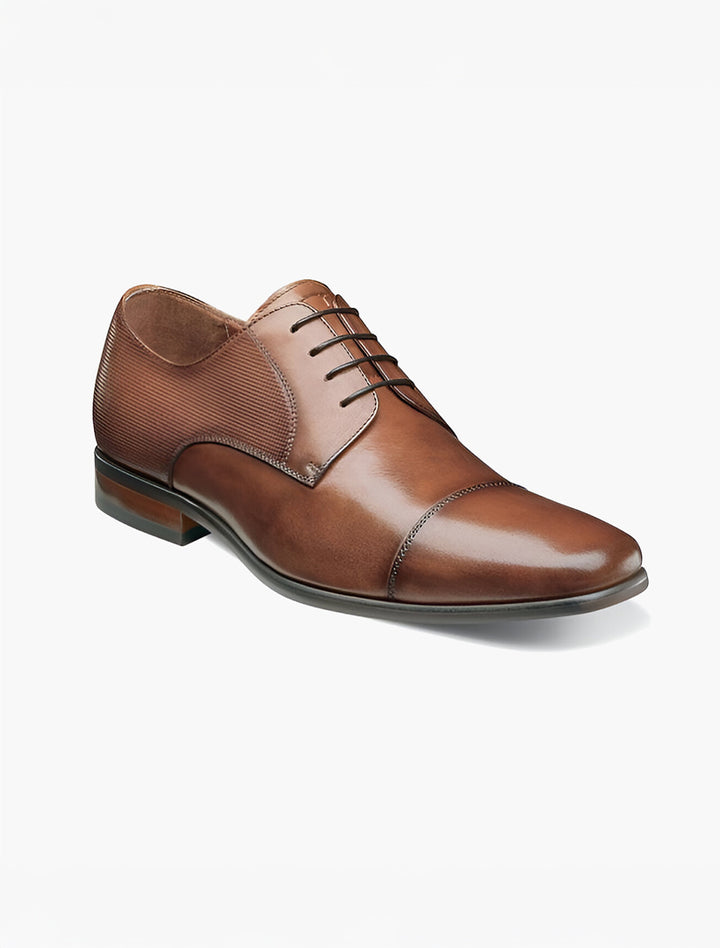 The Florsheim Cognac Cap Toe Oxford Shoe by Florsheim is a brown leather dress shoe with Flexsole Technology, lace-up closure, and a low heel, shown against a plain white background.
