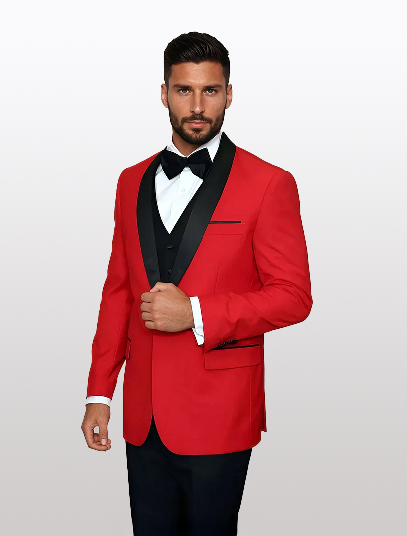 A man in a Statement Men's Red with Black Lapel Vested 100% Wool Tuxedo, featuring a tailored fit red jacket, black lapel, white shirt, black bow tie, and black pants stands against a plain white background.