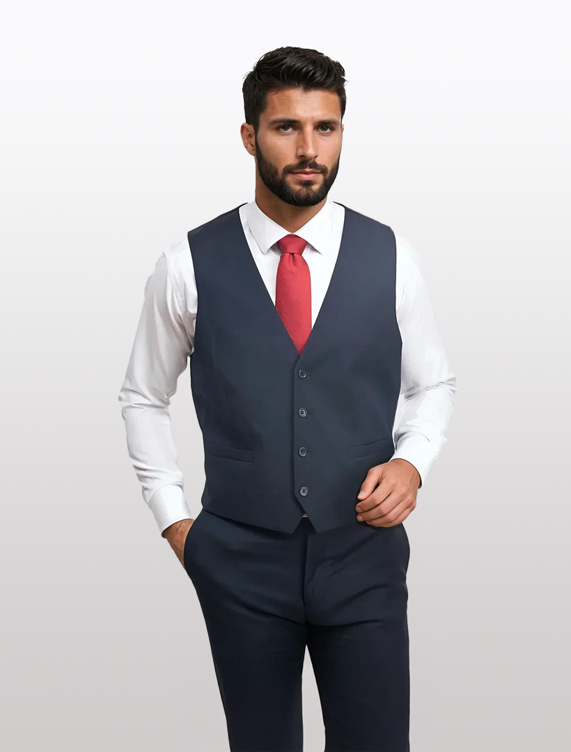 A man in a Navy Men's Slim-Fit Suit Separates Vest by Karako Separate, matching trousers, a white dress shirt, and red tie stands with one hand in his pocket against a plain light background.
