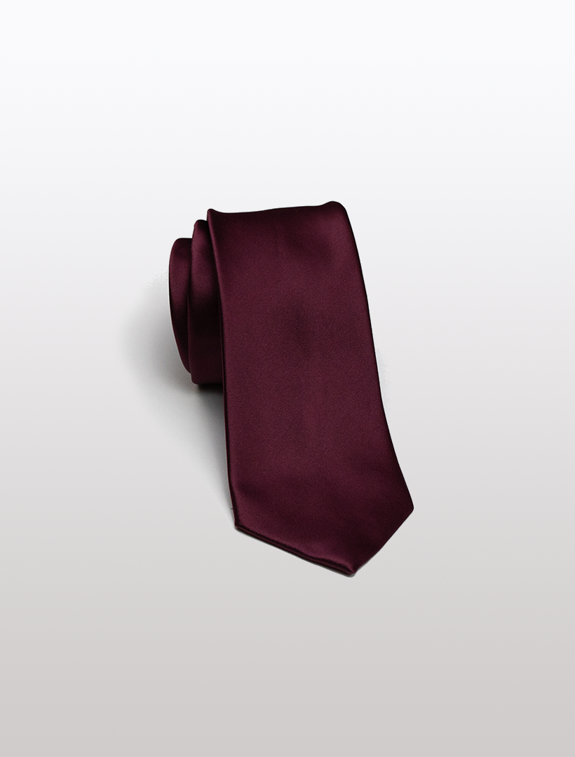 A Burgundy Men's Microfiber Tie from Karako Collecti, elegantly rolled up on a simple white background, is ideal for enhancing any formal look when paired with Karako Suits.