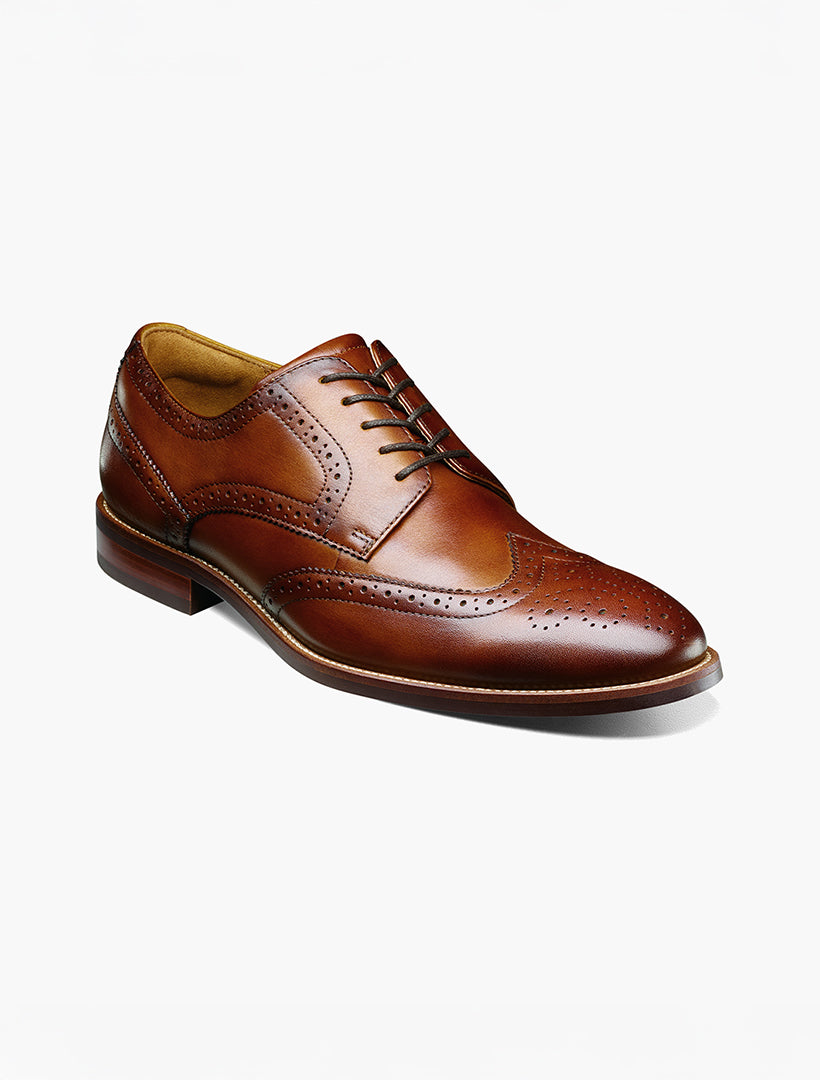 The Florsheim Cognac Wingtip Oxford Shoe features a brown leather upper with brogue detailing and laces, displayed against a plain white background.