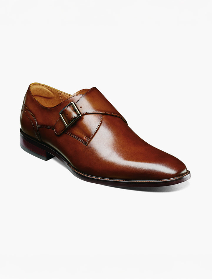 The Florsheim Cognac Plain Toe Single Monk Strap Shoe features a brown leather upper, side buckle, low heel, and stitched detailing, displayed on a white background.
