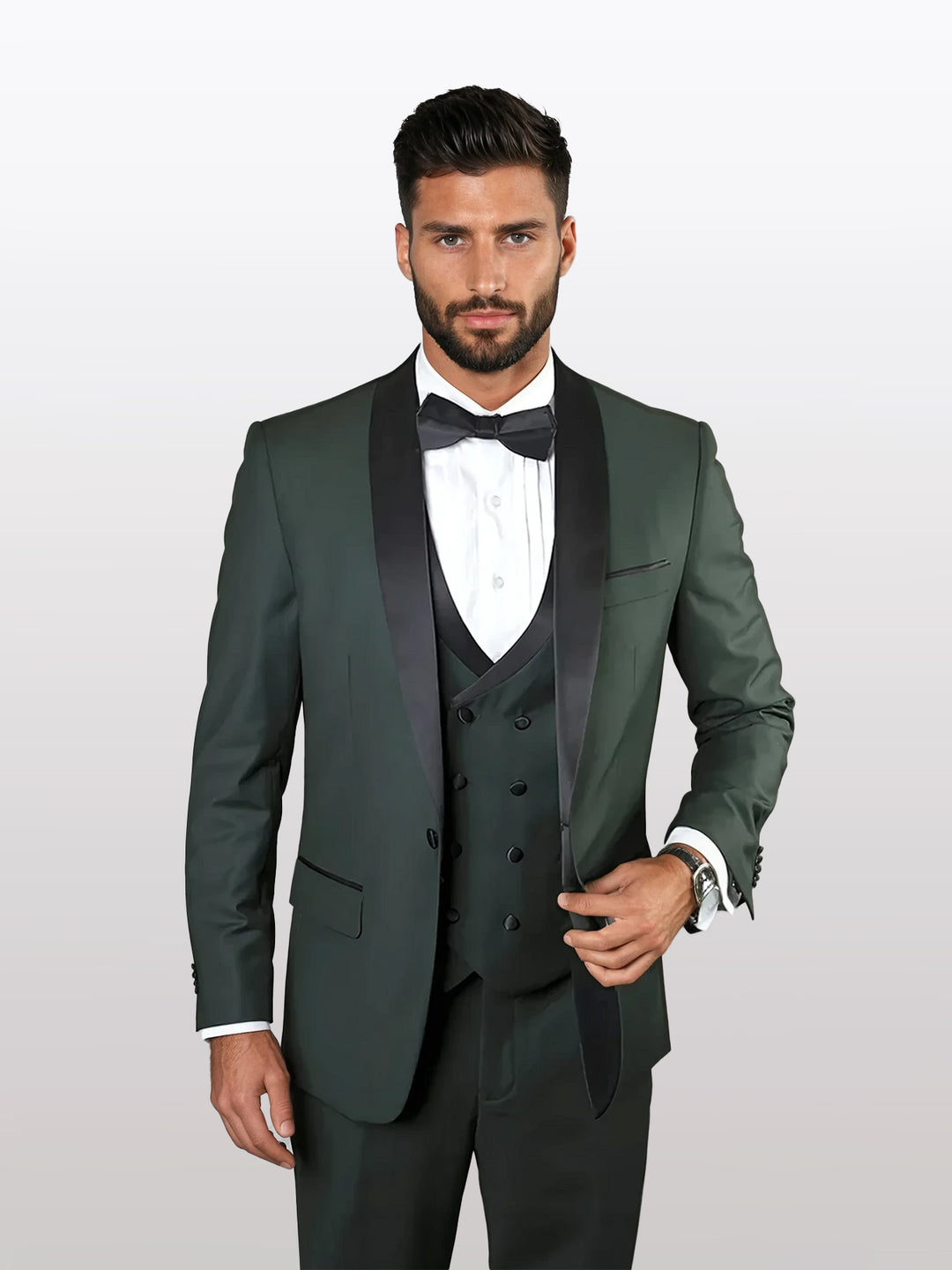 A person wears the Statement Men's Hunter Green Vested Tuxedo with black trim shawl lapel, expertly tailored from 100% wool, standing against a light background. The sleek black bow tie completes their sophisticated look.