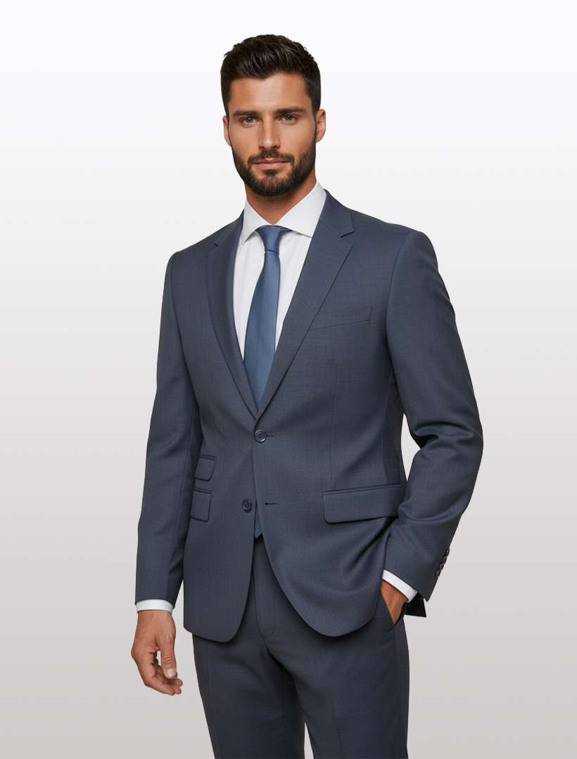 A man with short dark hair and a beard is wearing the Karako Men Mens Charcoal Suit, along with a white dress shirt and blue tie, standing against a plain light background.
