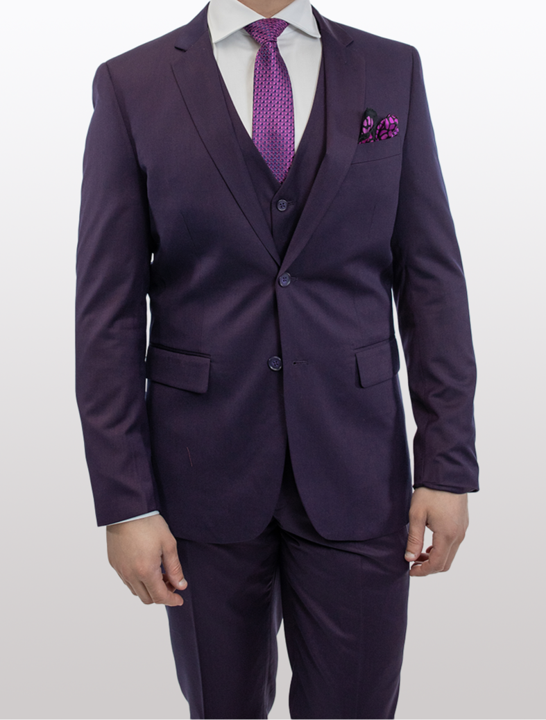 A person stands against a plain background, wearing the FUBU Purple Vested Suit by Fubu The Colle, featuring a slim fit design crafted from luxurious tetron rayon, complete with a matching vest and tie.