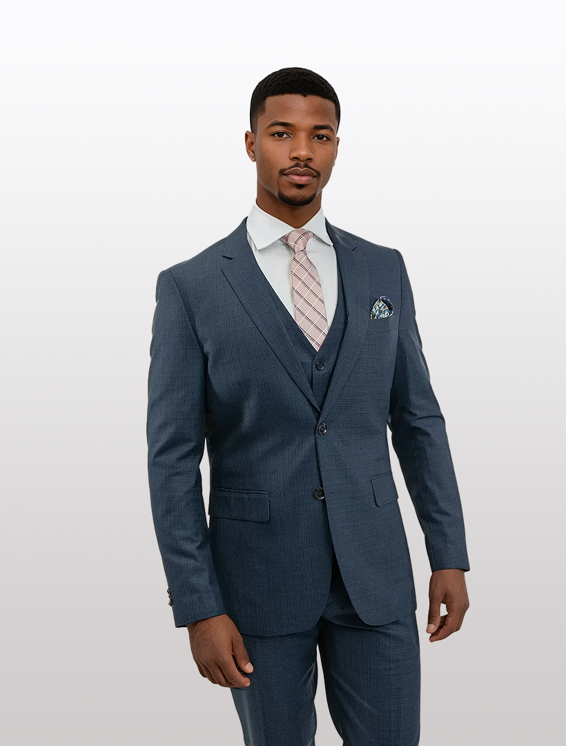 A man in a slim fit, blue FUBU Glen Check Vested Suit by Fubu The Colle, paired with a white shirt and striped tie, stands against a plain background.