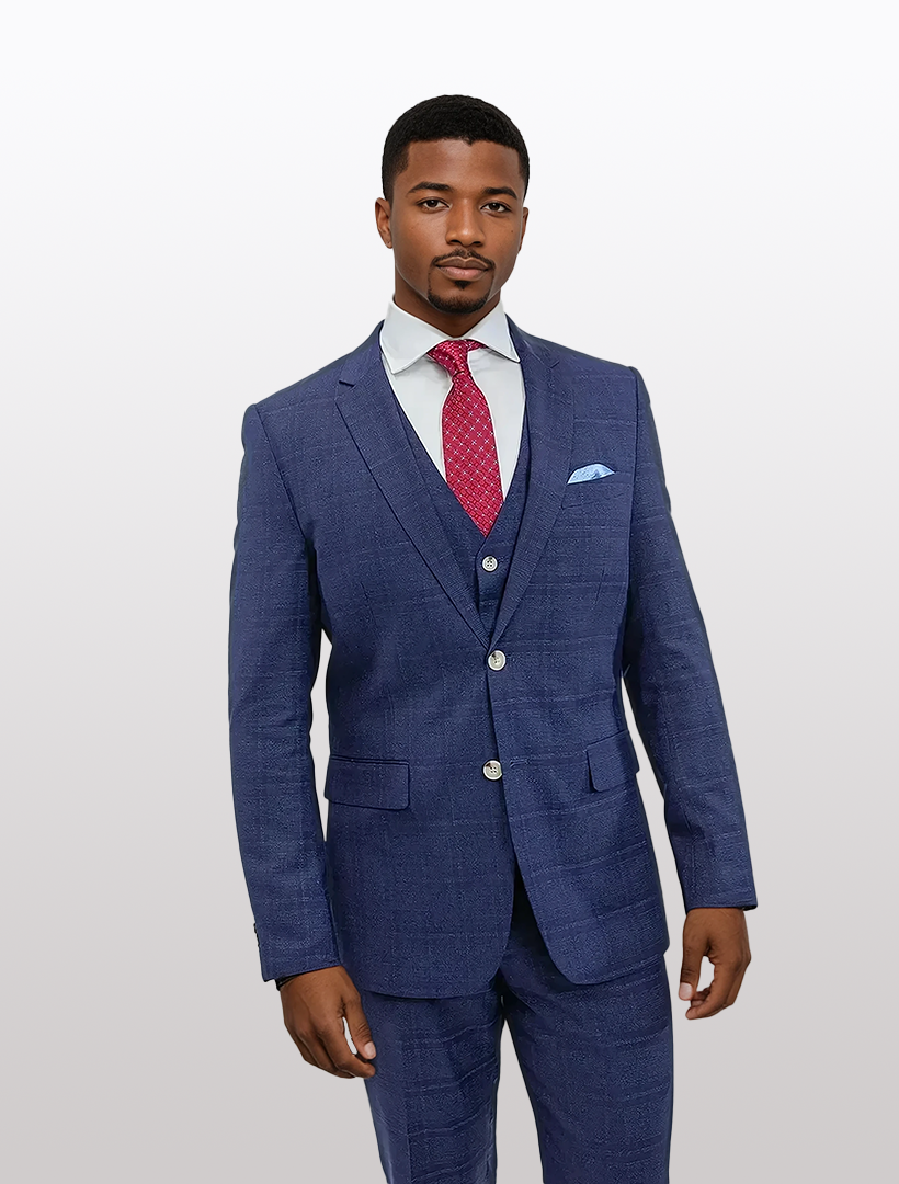 A man in a slim FUBU Blue Graphic Vested Suit by Fubu The Colle, paired with a red tie and matching pocket square, stands effortlessly against a plain background.