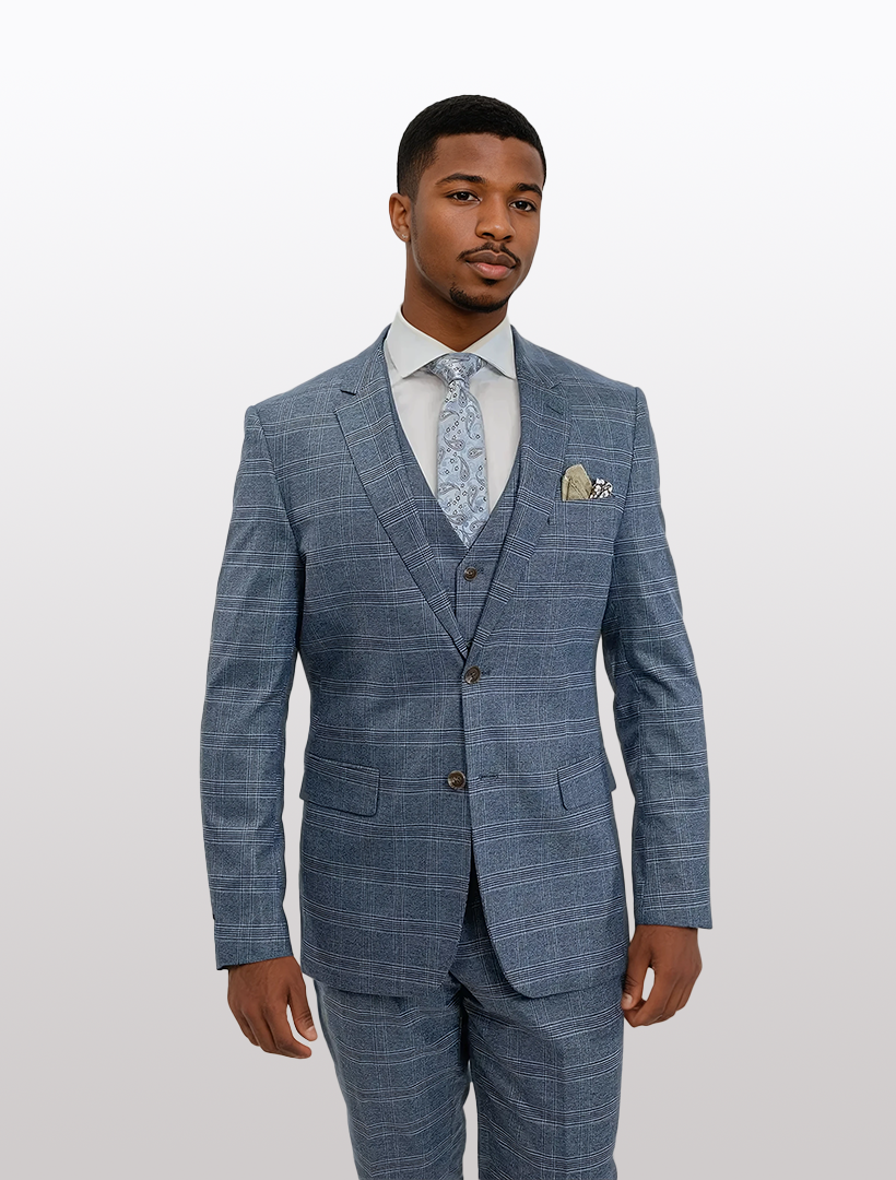 A person in a FUBU Light Blue Tartan Check Vested Suit by Fubu The Colle, paired with a light blue patterned tie, stands against a plain background.