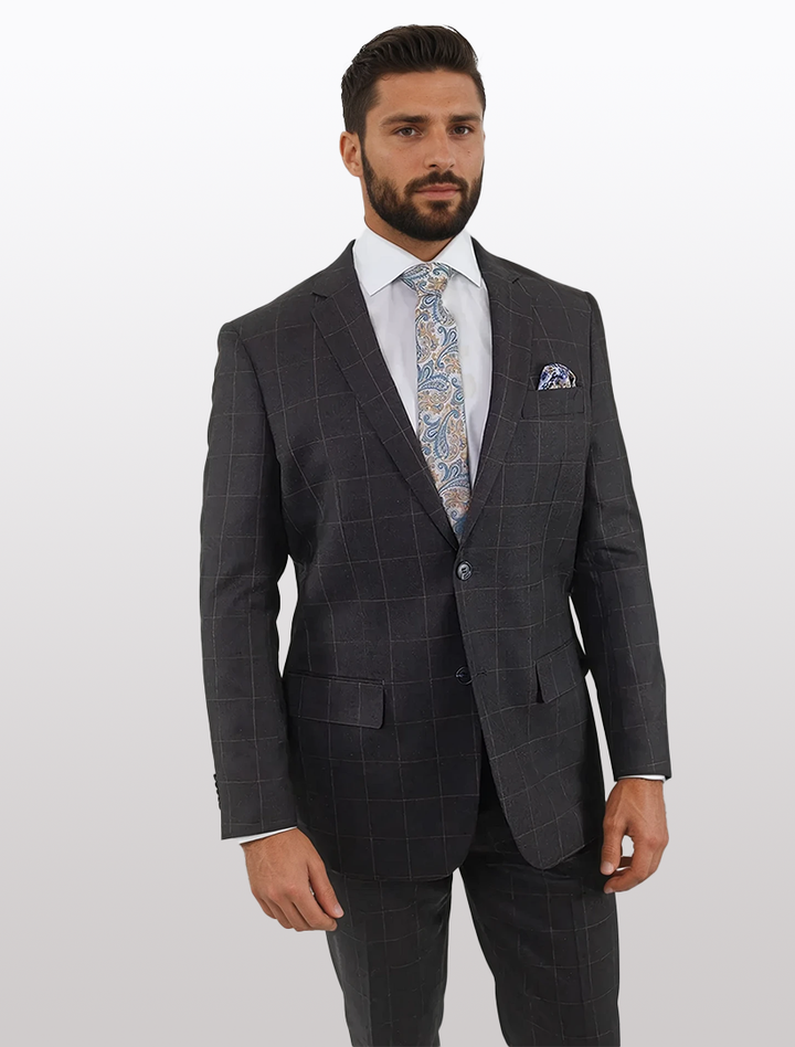 A bearded man stands against a plain background, dressed in a Karako &amp; Sons Men&
