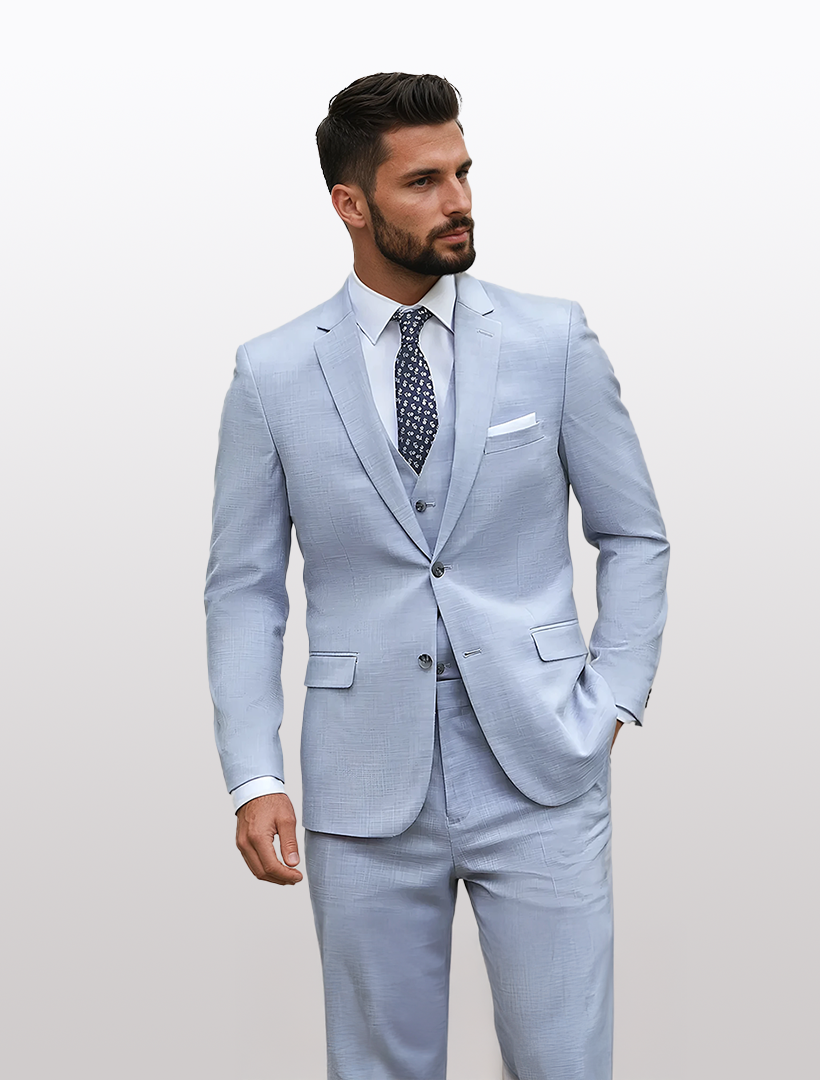 A man in a slim fit, light blue Couture 1910 suit jacket with a patterned tie stands against a plain background, showcasing high-performance stretch fabric for ultimate comfort and style.