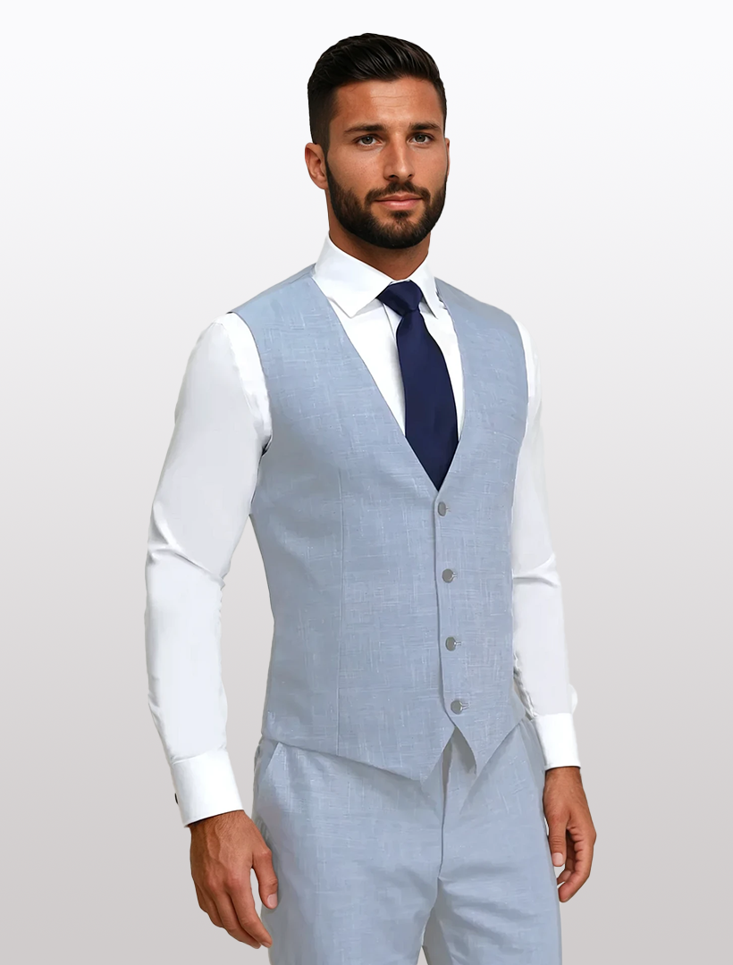 A man in a Couture 1910 light blue slim fit suit vest, made from high-performance stretch Tetron Rayon, pairs it with a crisp white shirt and navy tie, against a plain background.
