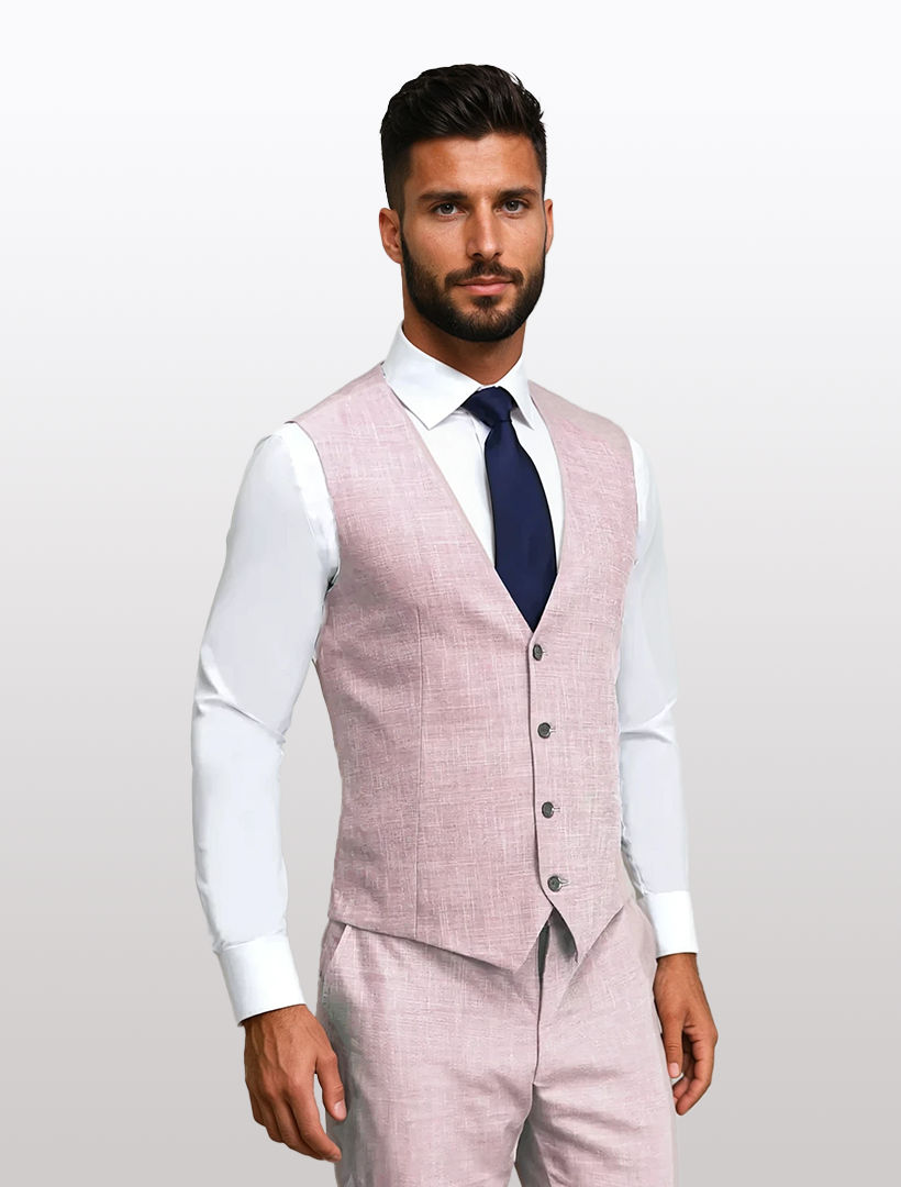 A man in a slim fit suit from Couture 1910, featuring a rose jacket crafted from Tetron Rayon, paired with a white shirt and dark blue tie, stands against a plain background.