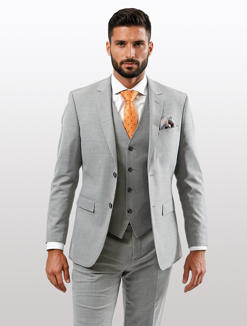 A man in a stylish Light Grey Slim-Fit Suit Separates Jacket by Karako's Suits, paired with a vest, white shirt, and orange polka dot tie, stands against a white background.