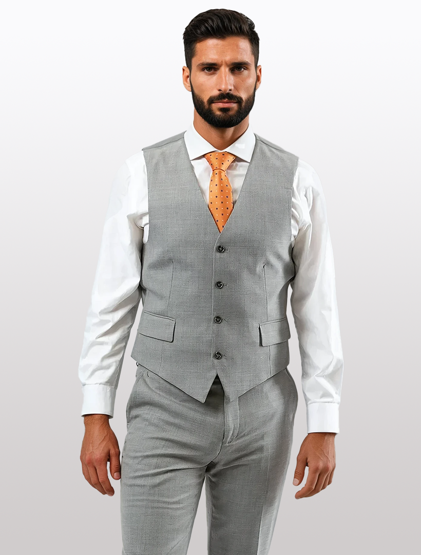 A man wears a Light Grey Men's Slim-Fit Suit Separates Vest by Karako Separate with matching pants, a white shirt, and an orange dotted tie, standing facing forward against a plain background.