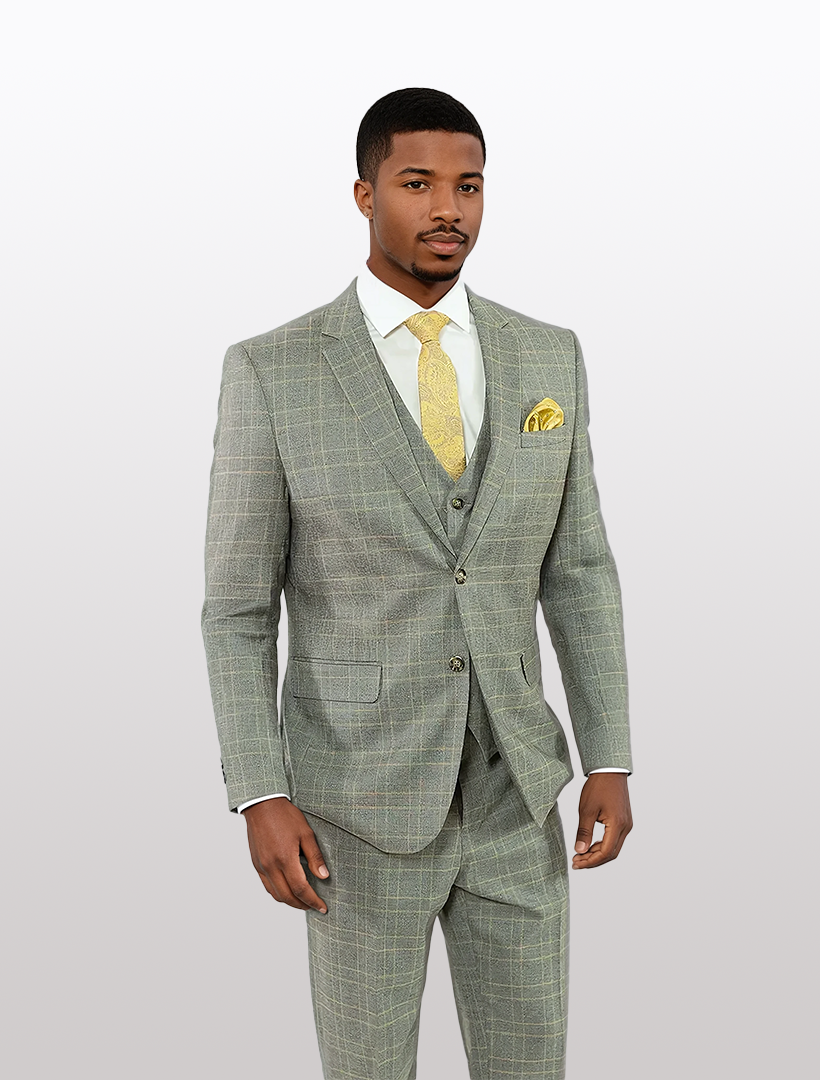 A man models the FUBU Grey with Yellow Double Windowpane Vested Suit by Fubu The Colle, featuring a stretch armhole design, paired with a yellow tie and pocket square against a plain background.