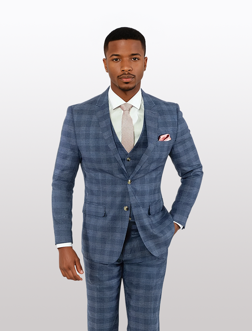 A person in a sharp FUBU Sapphire Blue Glen Check Vested Suit by Fubu The Colle, paired with a crisp white shirt and tie, stands against a plain background.