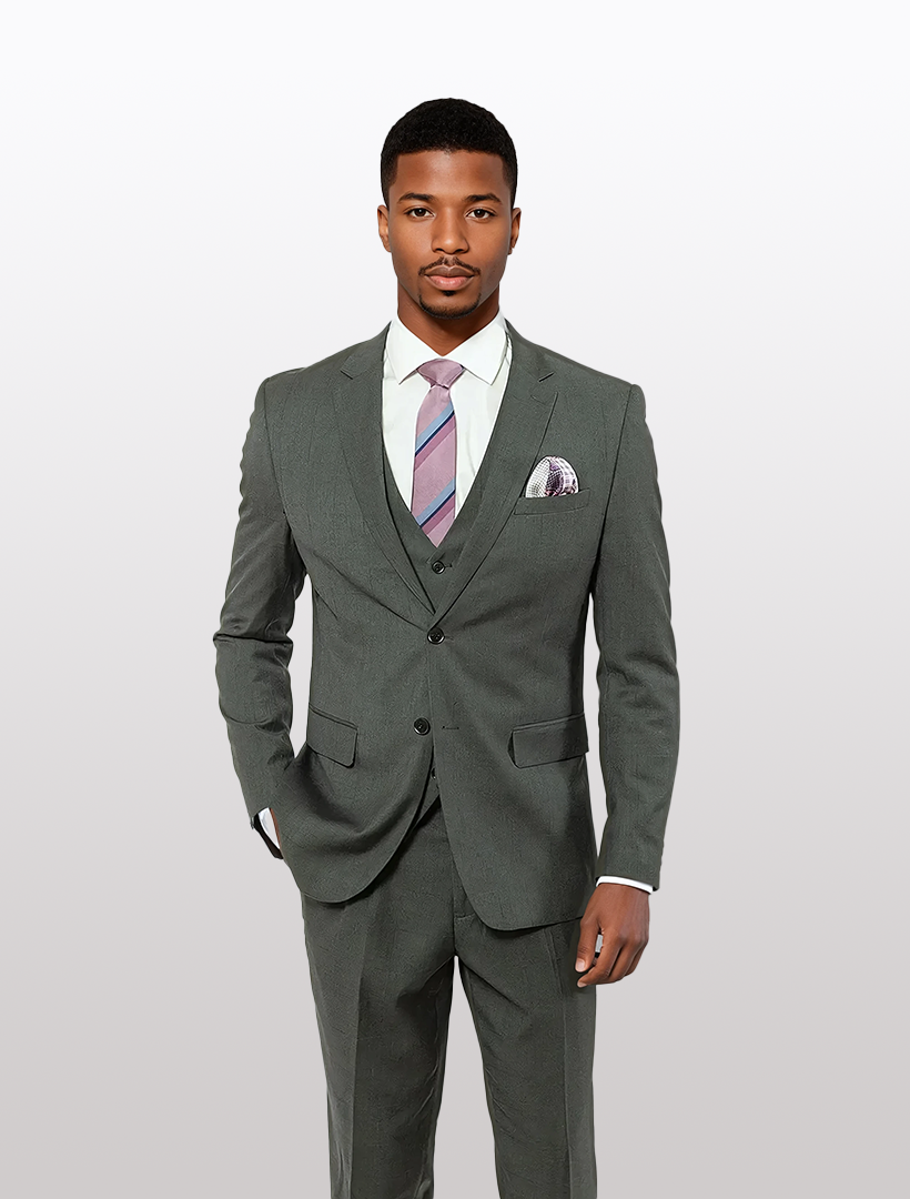 A man in a FUBU charcoal suit with blue and red pinstripe, featuring a stretch armhole design for comfort, wears a pink and gray striped tie against a white background.