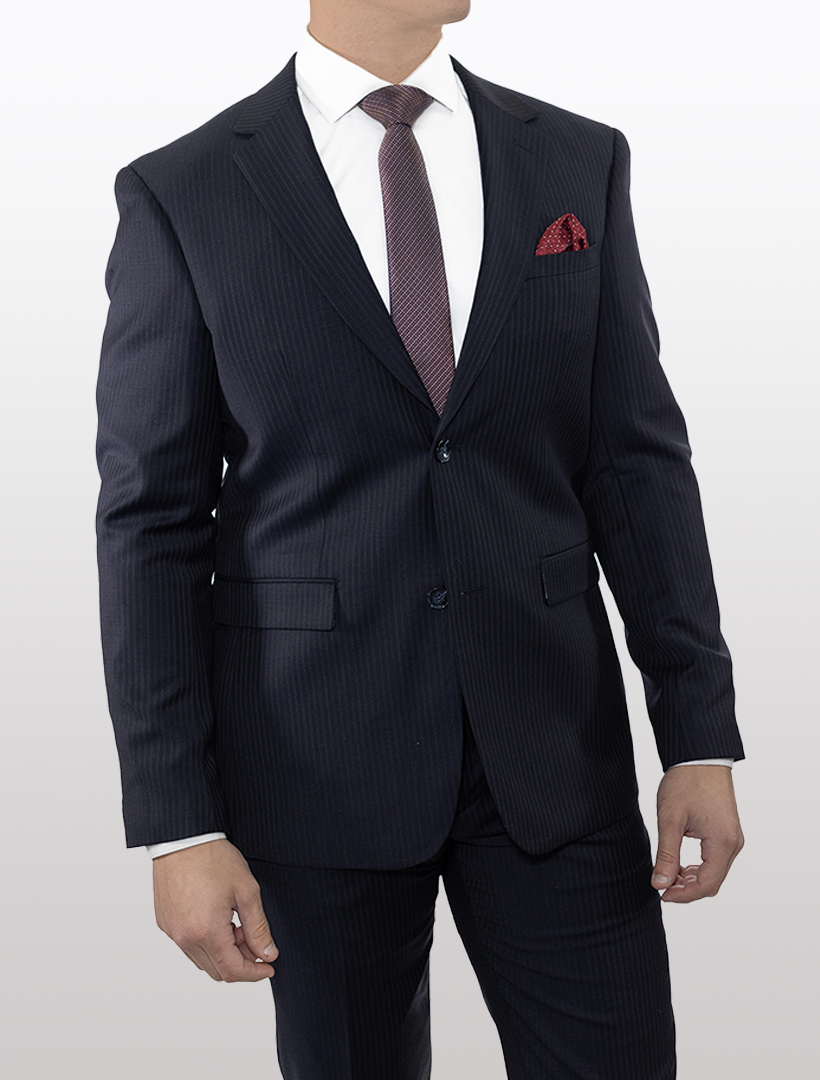 A person wearing a Douglas Grahame Men's Navy Chalk Stripe Wool Slim Fit Suit, complemented by a red tie and pocket square, looks to the side against a plain background.