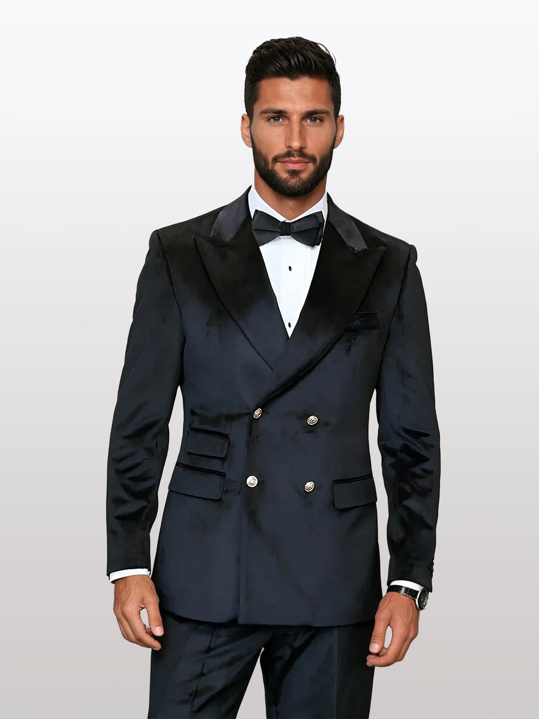 A man wearing a Statement Men's Black Double Breasted Velvet Suit with a bow tie stands against a plain background.