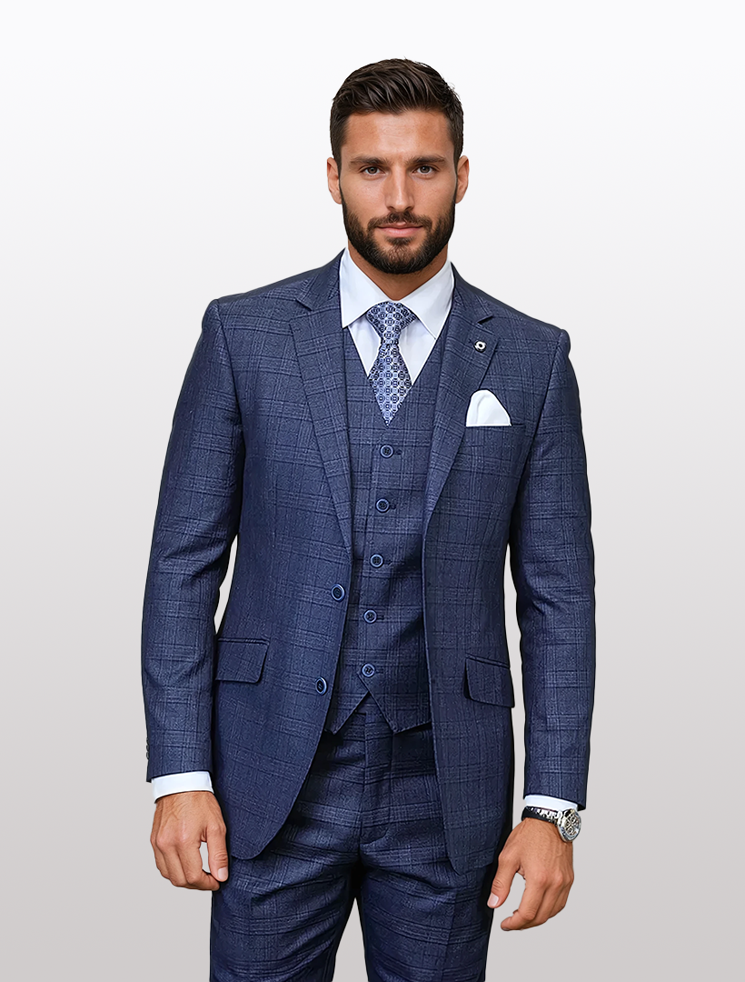 A man dons a Statement Men's Indigo Windowpane Plaid Modern Fit 100% Wool Vested Suit, paired with a white shirt and patterned tie. Against a plain backdrop, the suit's stretch armhole enhances his silhouette.