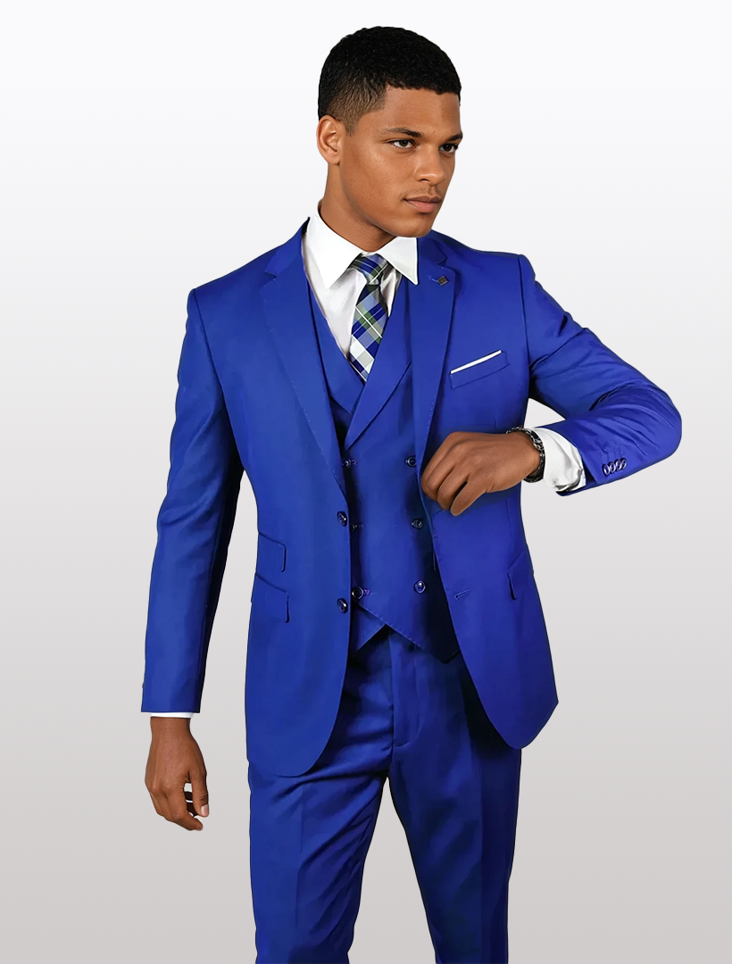A person wearing a Statement Mens Royal Blue Modern Fit 100% Wool Vested Suit stands against a plain background, adjusting their sleeve while looking to the side.