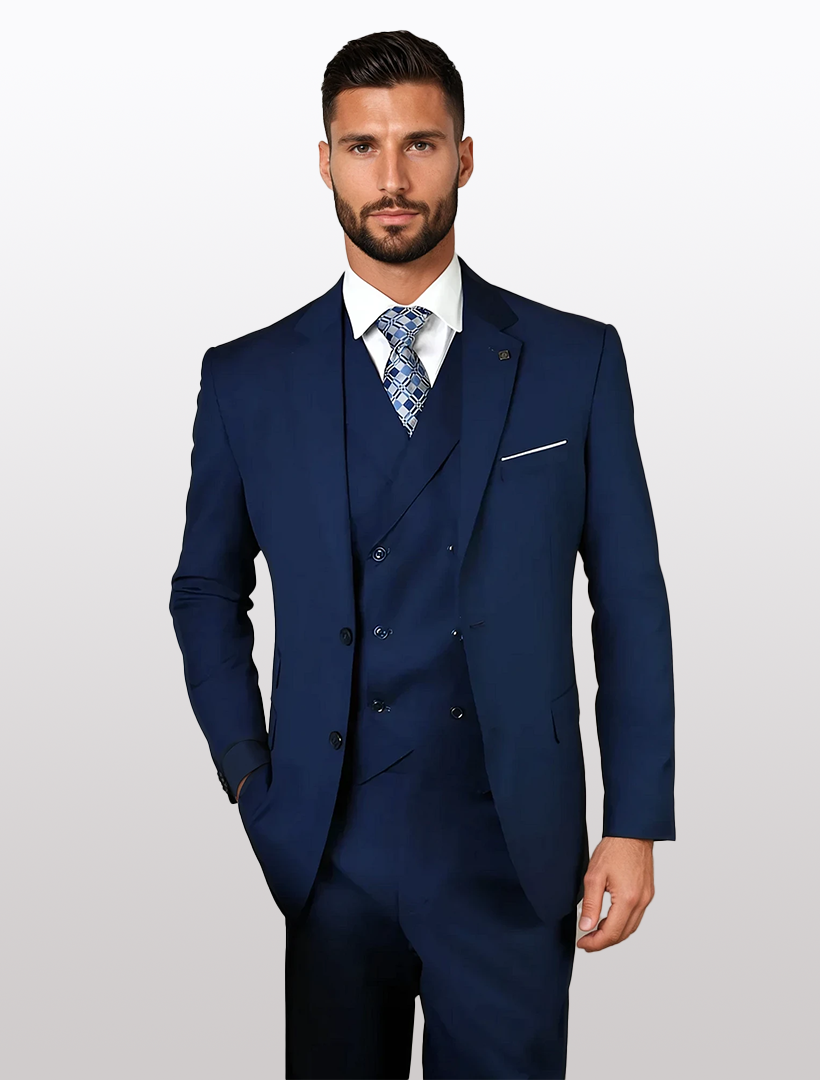 A man in a Statement Mens Sapphire Blue Modern Fit 100% Wool Vested Suit, paired with a white shirt and patterned tie, stands gracefully against a plain background.