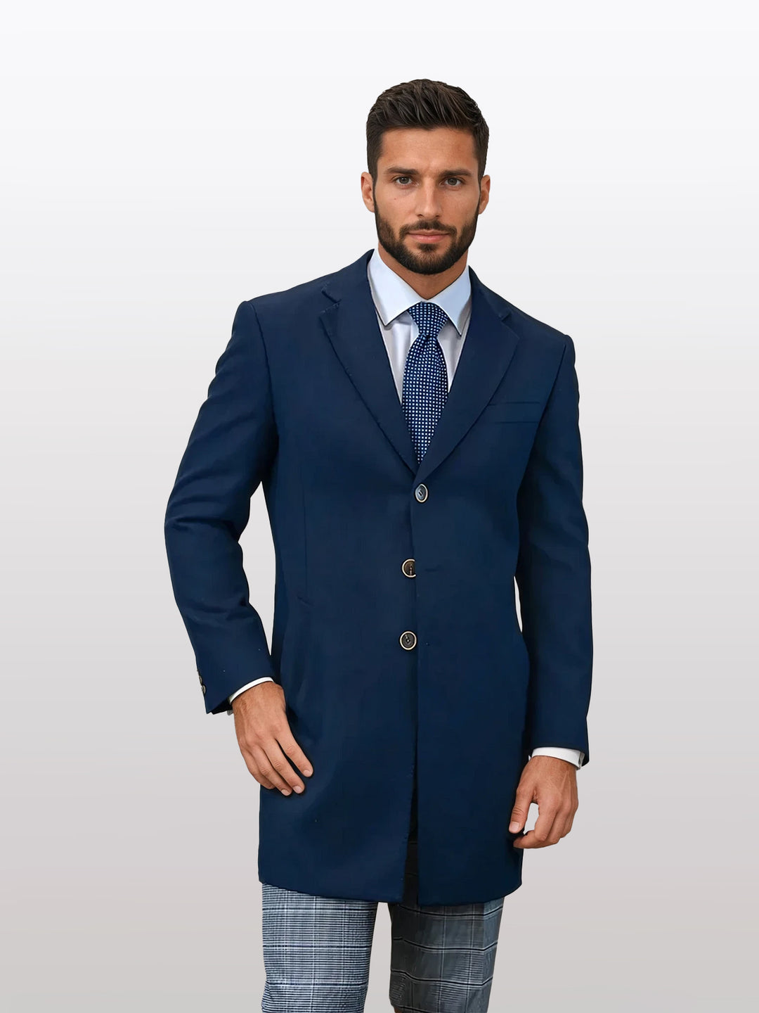 A man wearing a Statement Men's Solid Navy 100% Wool Over Coat stands against a plain background, paired with a white shirt and patterned tie, featuring a modern fit jacket with expertly tailored stretch armholes for comfort.