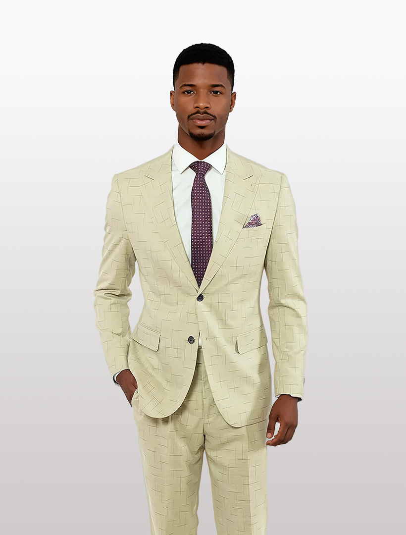 A man stands against a plain light background in a FUBU Tan with Navy Fading Windowpane Peak Lapel 2-Piece Suit by Fubu The Colle, paired with a white shirt and dark tie.