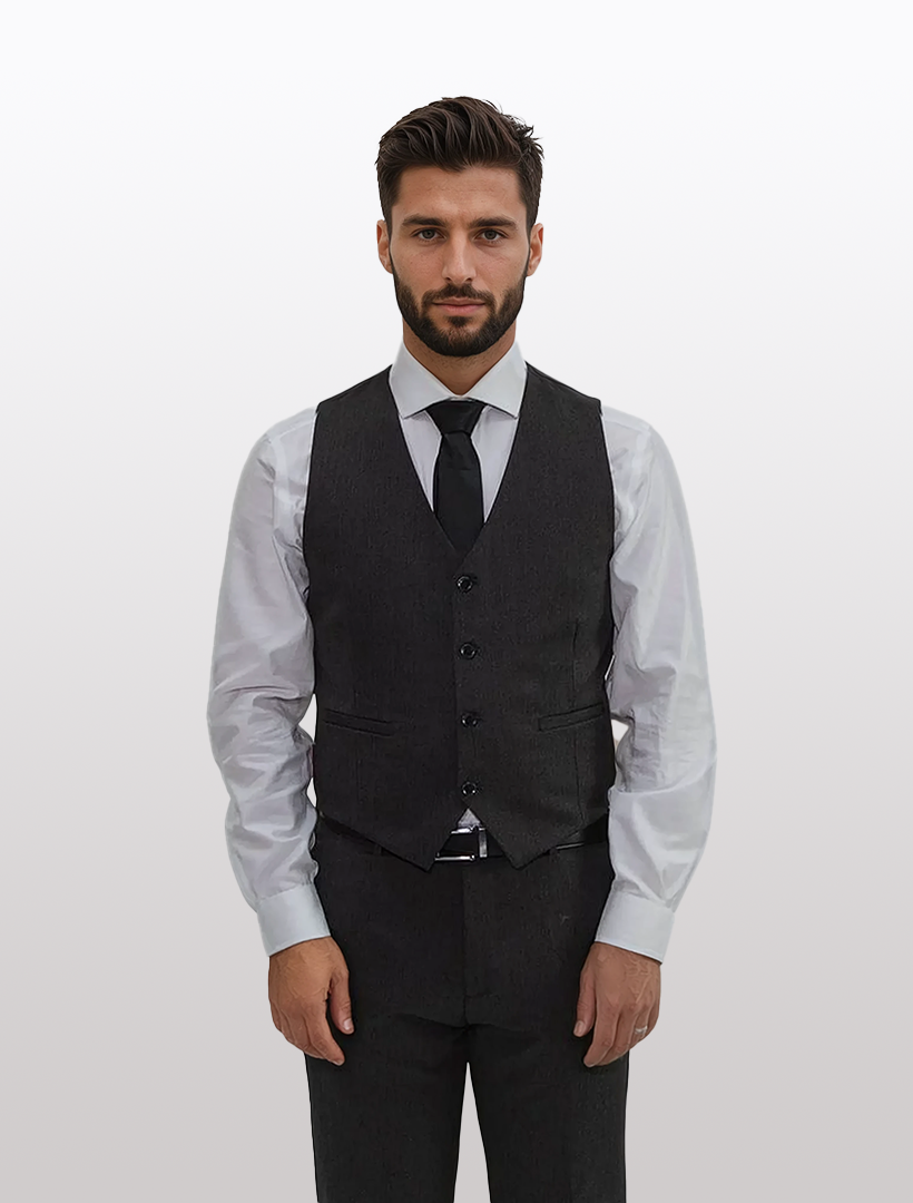 A man in a dark gray three-piece suit featuring a FUBU Black Separates Slim-Fit Vest and black tie stands against a plain white background.