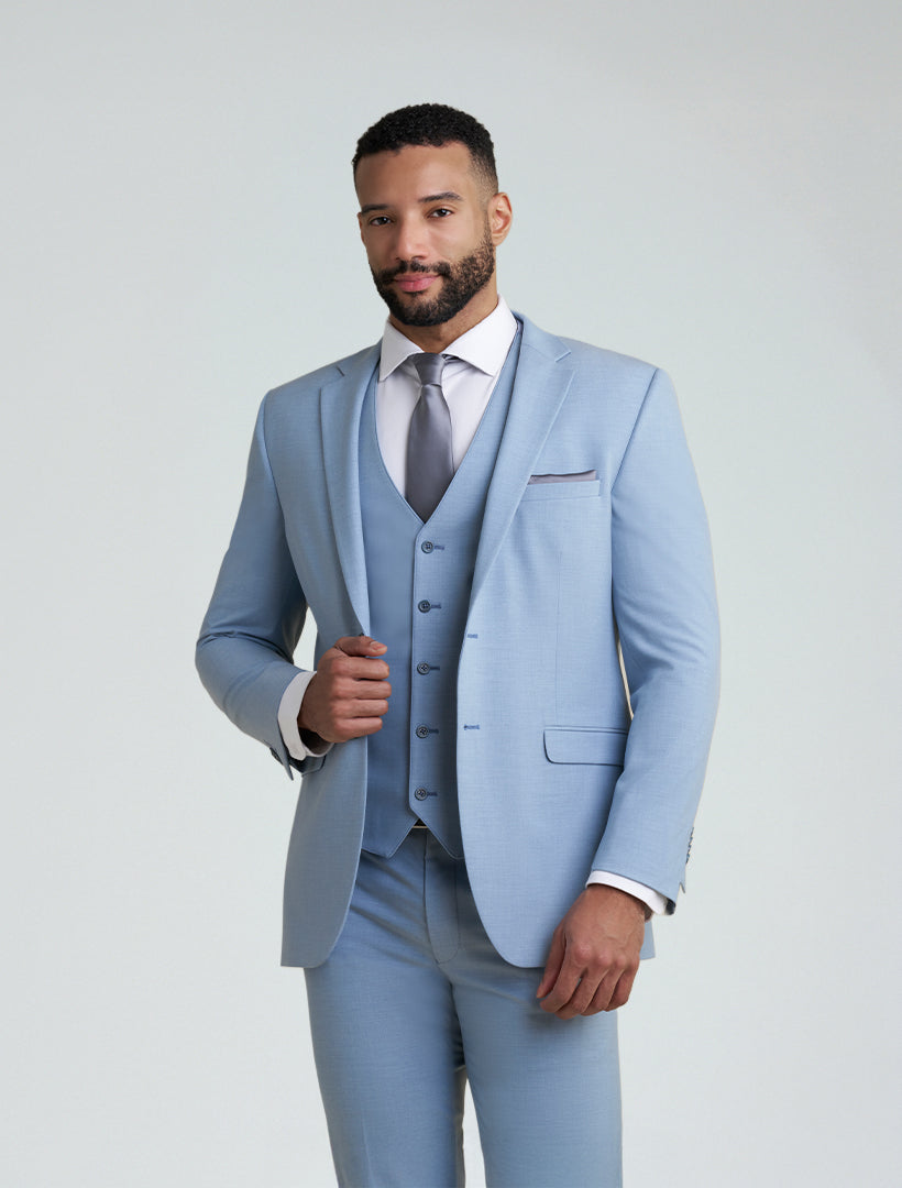 A man stands against a plain light background wearing the Allure Men's Light Blue Tailored Fit Suit Jacket, paired with a white dress shirt and gray tie.